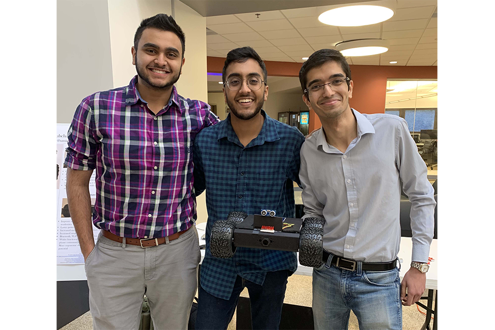 3 students with robot in EECS atrium