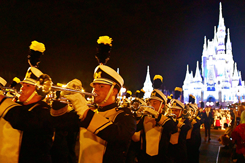 Connor marching with the Michigan Marching Band in Disneyworld with palace in the background